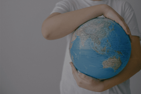 Persoon die een wereldbol vasthoudt als symbool voor veilig reizen met Reisprik.