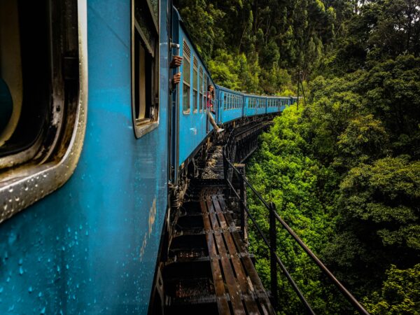 Blauwe trein die door de groene heuvels van Sri Lanka rijdt, een van de bekendste treinroutes ter wereld.